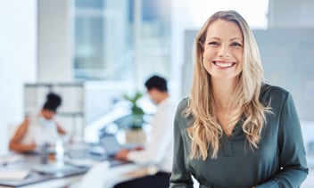 Female leader, manager or CEO with a smile, mission and vision in the office and her team in the background.