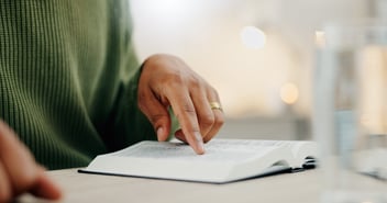 Hand pointing at a book